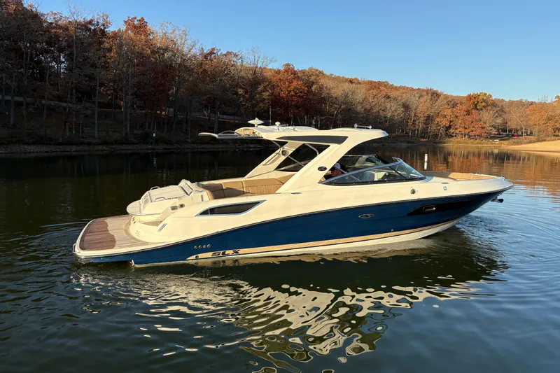 Slide: The Image of 2016 Sea Ray 350 SLX boat cruising on a calm lake with autumn trees in the background. - 4