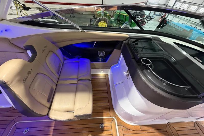 Slide: The Image of 2016 Sea Ray 350 SLX boat interior with seating and blue accent lighting in a garage. - 51