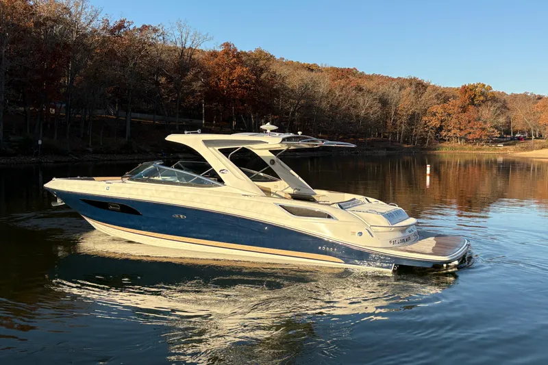 Slide: The Image of 2016 Sea Ray 350 SLX boat cruising on a calm lake with autumn trees. - 6