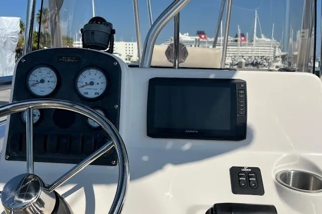 Slide: The Image of 2007 Sea Hunt Triton 207 dashboard with Garmin display and gauges, docked near cruise ships. - 10