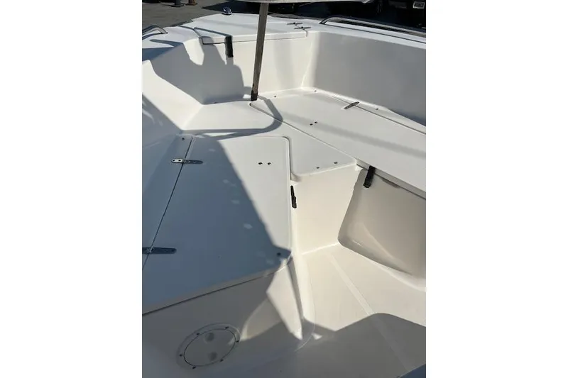 Slide: The Image of 2007 Sea Hunt Triton 207 boat interior with white seating and storage compartments. - 11