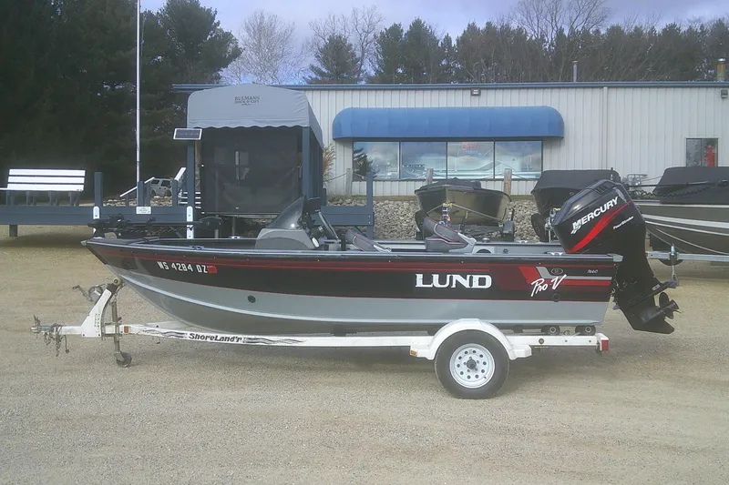 Slide: The Image of 1997 Lund 1660 Pro-V fishing boat on trailer with Mercury outboard motor. - 1