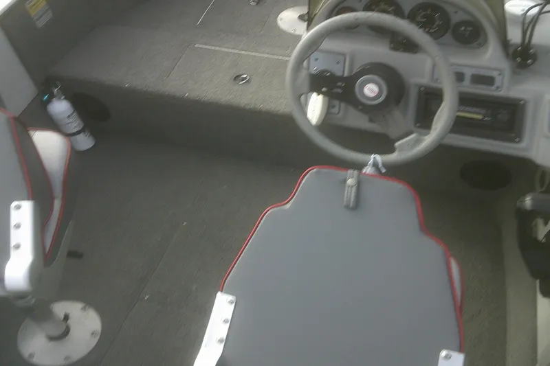 Slide: The Image of 1997 Lund 1660 Pro-V boat interior with steering wheel and seating. - 11