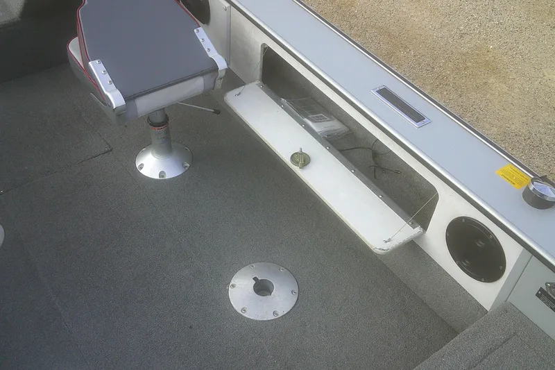 Slide: The Image of 1997 Lund 1660 Pro-V boat interior with seat and storage compartment. - 14