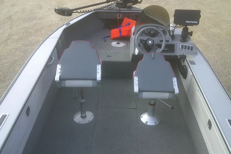 Slide: The Image of 1997 Lund 1660 Pro-V boat interior with steering wheel, seats, and navigation equipment. - 15