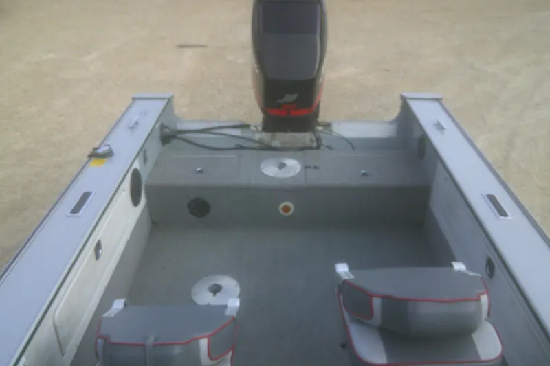 Slide: The Image of 1997 Lund 1660 Pro-V boat interior with motor, featuring seating and storage compartments. - 16