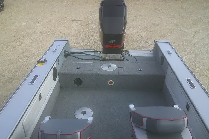 Slide: The Image of 1997 Lund 1660 Pro-V boat interior with motor, gray seating, and storage compartments. - 17