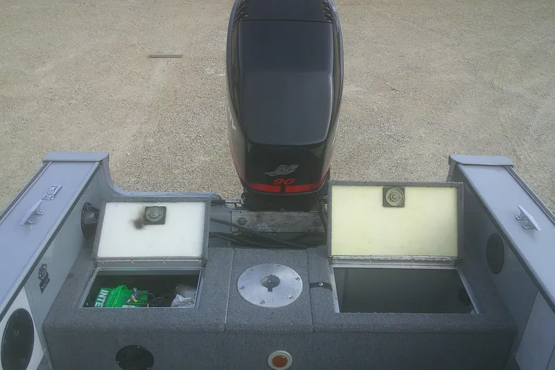 Slide: The Image of 1997 Lund 1660 Pro-V boat interior with open compartments and outboard motor. - 18