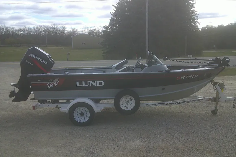 Slide: The Image of 1997 Lund 1660 Pro-V fishing boat on trailer with Mercury outboard motor. - 25