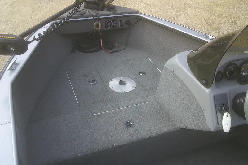 Slide: The Image of 1997 Lund 1660 Pro-V boat interior with steering console and carpeted deck. - 3