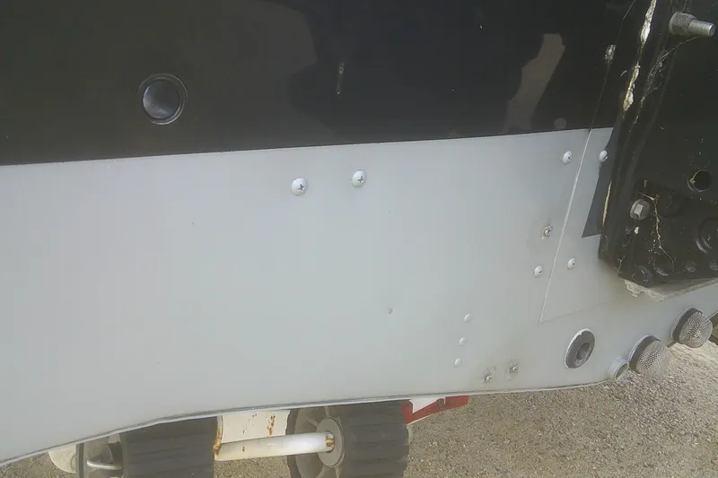 Slide: The Image of Close-up of a 1997 Lund 1660 Pro-V boat hull with visible rivets and fittings. - 30
