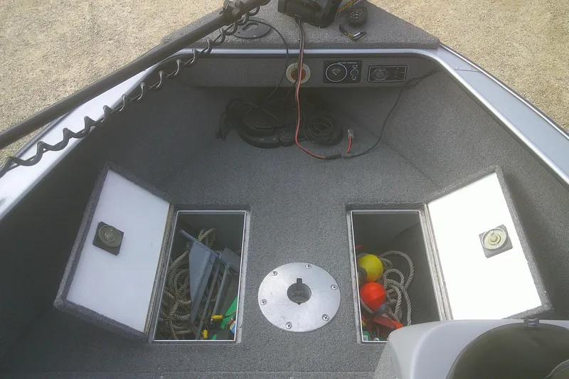 Slide: The Image of 1997 Lund 1660 Pro-V boat interior with storage compartments and fishing gear. - 4