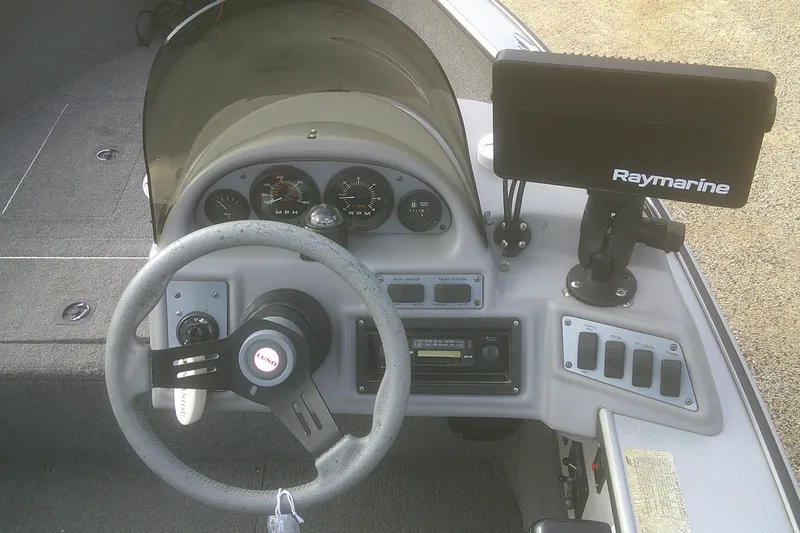 Slide: The Image of 1997 Lund 1660 Pro-V boat dashboard with steering wheel and Raymarine display. - 6