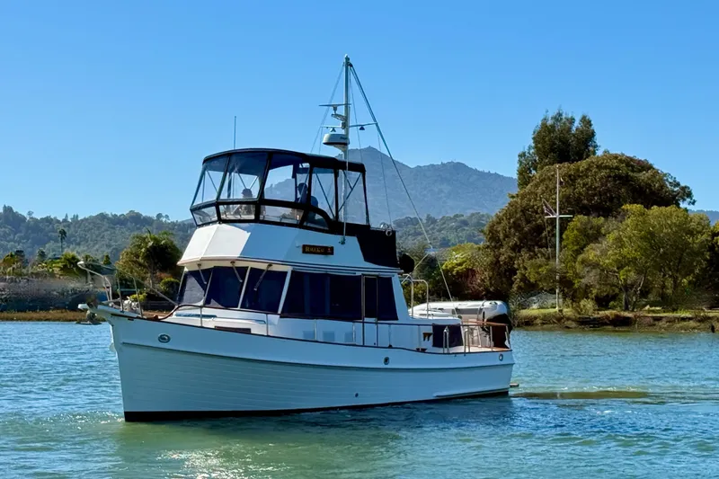 The Image of 1997 Grand Banks Classic yacht cruising on open sea under clear blue sky. - 0