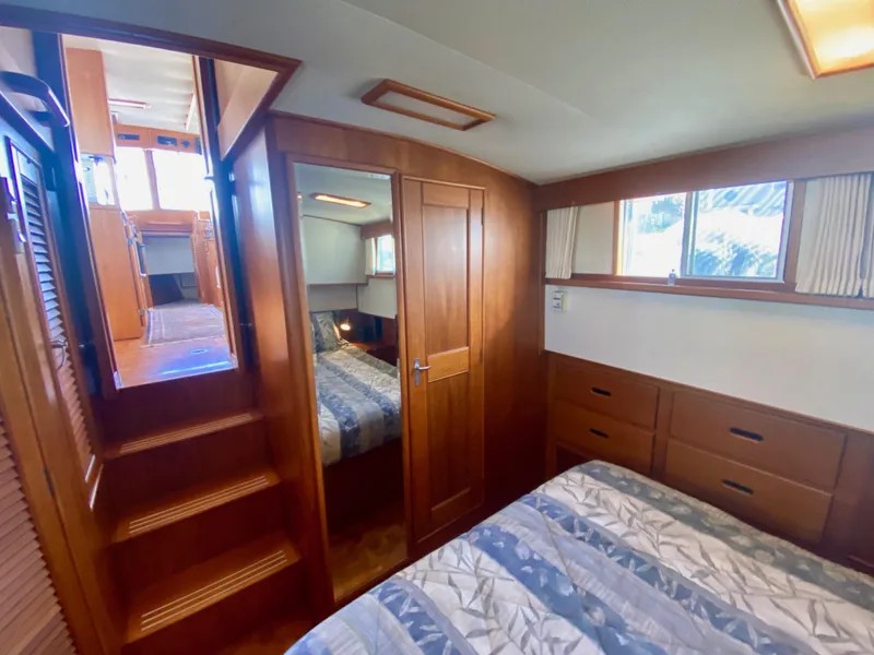 Slide: The Image of Cozy cabin interior of 1997 Grand Banks Classic yacht with bed, wooden cabinetry, and rug. - 28
