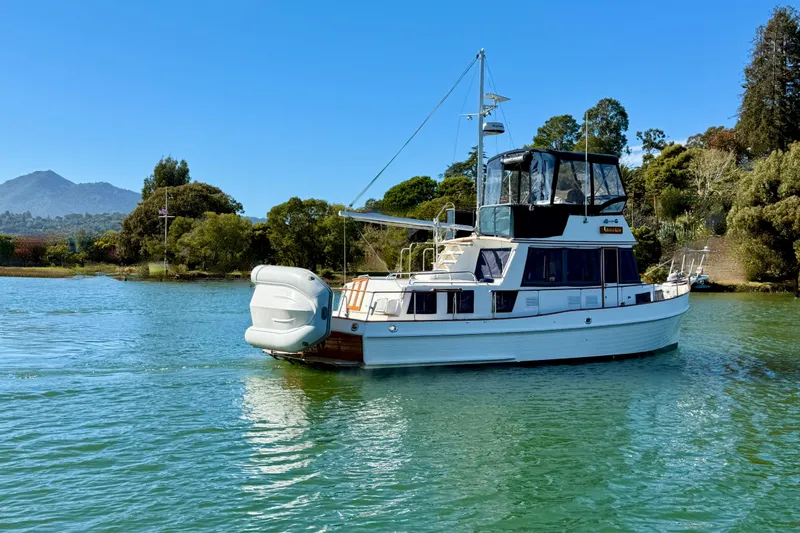 Slide: The Image of 1997 Grand Banks Classic yacht on serene water with scenic mountain backdrop. - 3