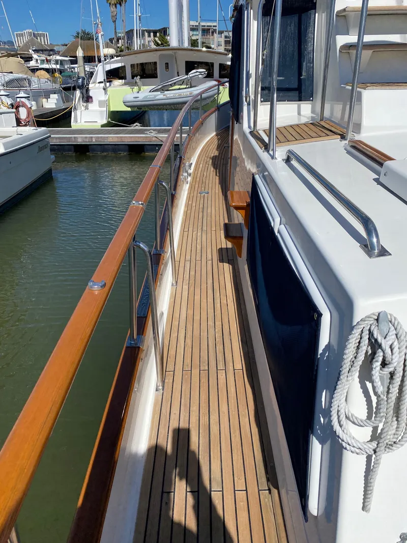 Slide: The Image of 1997 Grand Banks Classic yacht docked at marina, showcasing wooden deck and sleek design. - 41