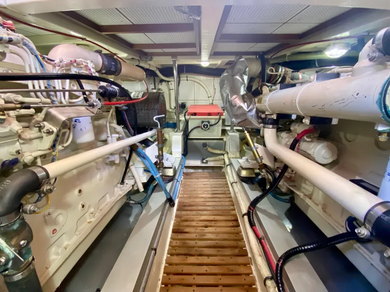 Slide: The Image of Engine room of a 1997 Grand Banks Classic boat with visible hoses and components. - 49