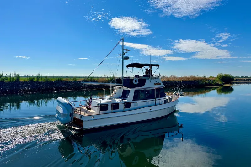 Slide: The Image of 1997 Grand Banks Classic yacht cruising on a sunny day, surrounded by calm waters. - 7