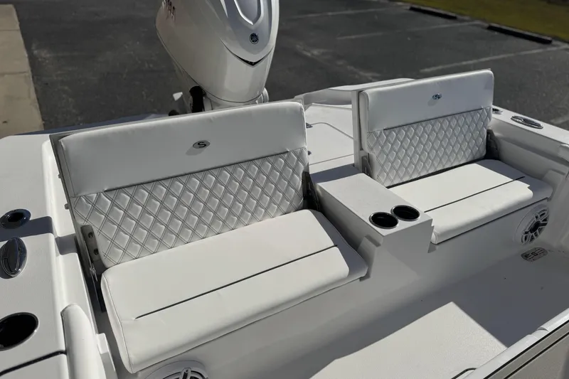 Slide: The Image of 2026 Sportsman Masters 267 Bay Boat with white cushioned seating and cup holders. - 14