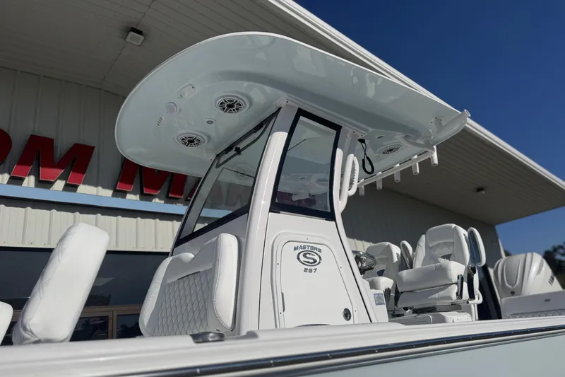 Slide: The Image of 2026 Sportsman Masters 267 Bay Boat with T-top and seating, displayed outdoors. - 6