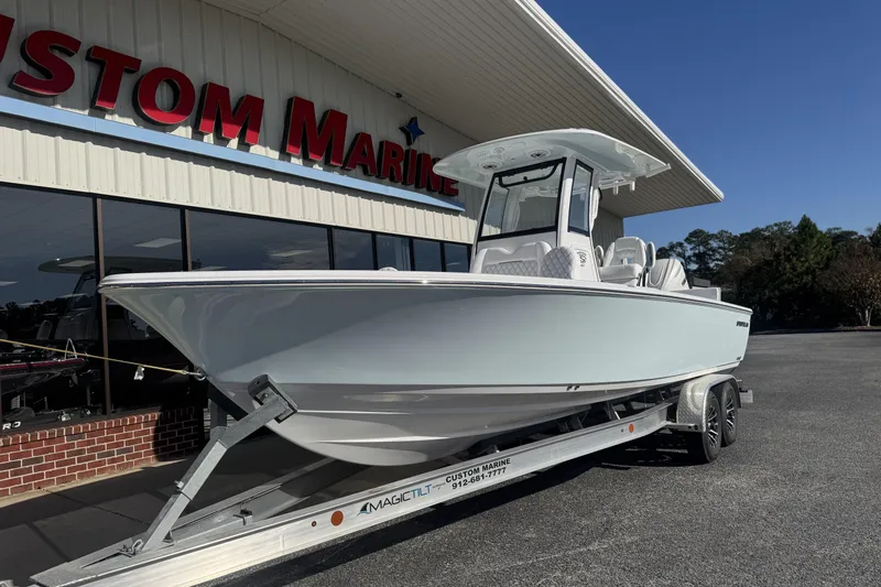 Slide: The Image of 2026 Sportsman Masters 267 Bay Boat on trailer outside Custom Marine dealership. - 7