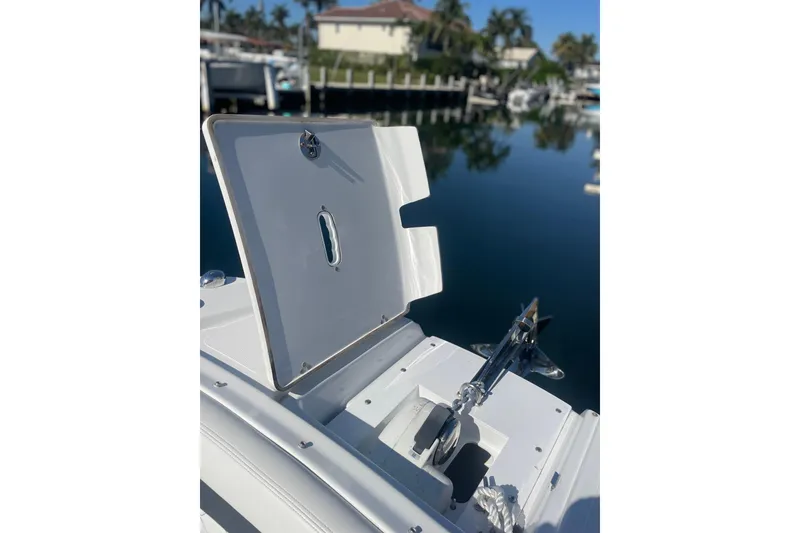 Slide: The Image of 2023 Four Winns HD5 OB boat anchor compartment open at marina. - 19