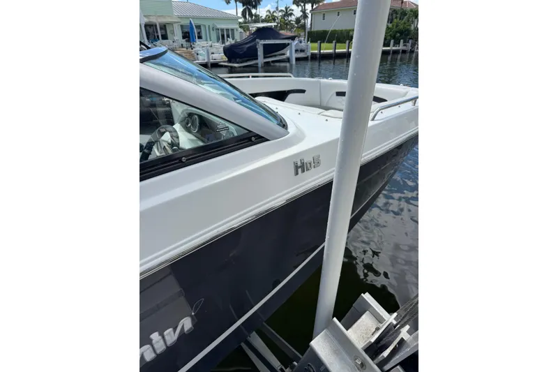 Slide: The Image of 2023 Four Winns HD5 OB boat docked near waterfront homes. - 2
