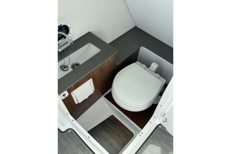 Slide: The Image of 2023 Four Winns HD5 OB boat interior with compact bathroom and sink. - 20