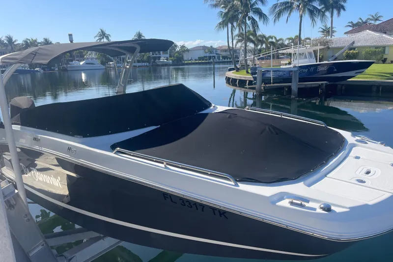 Slide: The Image of 2023 Four Winns HD5 OB boat docked in a sunny marina setting. - 3