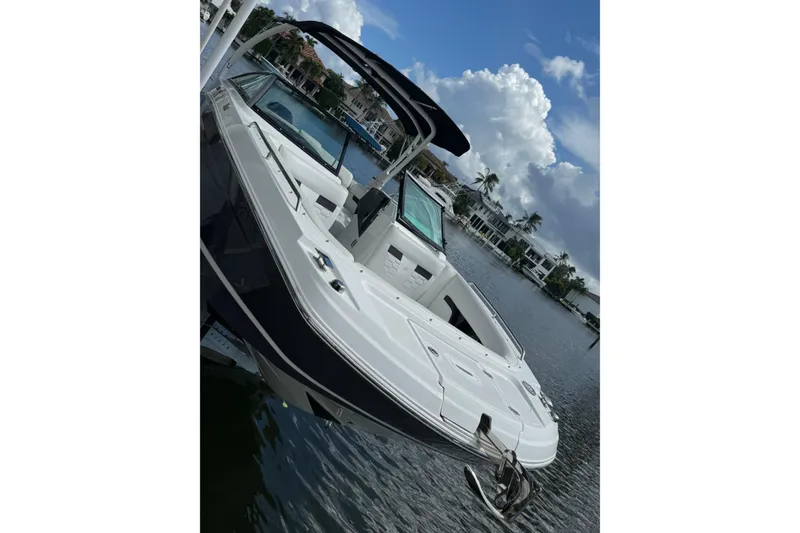 Slide: The Image of 2023 Four Winns HD5 OB boat docked on a sunny waterfront. - 4