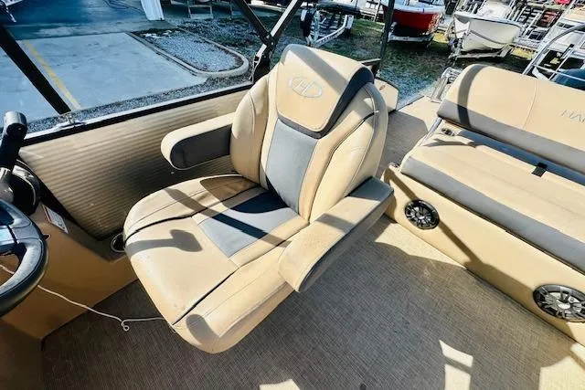 Slide: The Image of 2021 Harris 250 Cruiser boat interior with beige seating and steering wheel. - 15