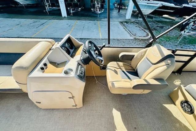 Slide: The Image of 2021 Harris 250 Cruiser boat interior with steering wheel and beige seating. - 16