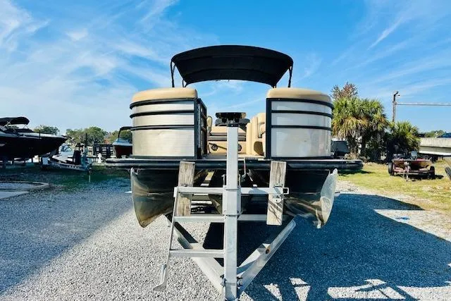 Slide: The Image of 2021 Harris 250 Cruiser pontoon boat on a trailer, under a clear blue sky. - 6