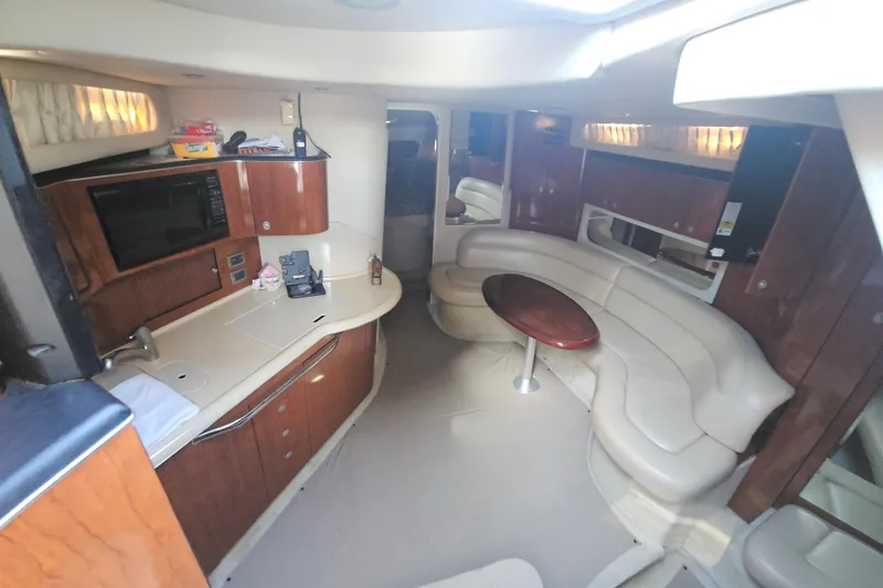 Slide: The Image of 2004 Sea Ray 380 Sundancer interior with kitchenette and curved seating area. - 11