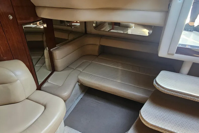 Slide: The Image of Luxurious interior of 2004 Sea Ray 380 Sundancer with beige leather seating and wood accents. - 16