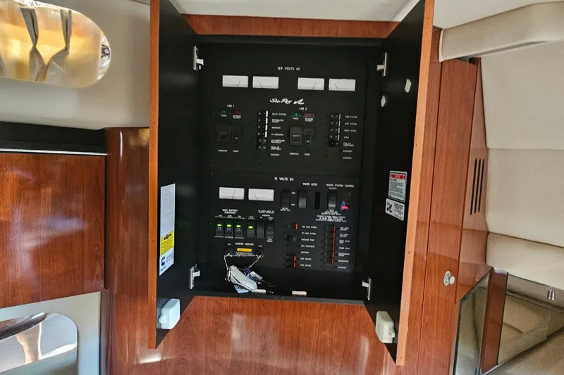 Slide: The Image of Electrical panel inside 2004 Sea Ray 380 Sundancer yacht, featuring wood cabinetry. - 17