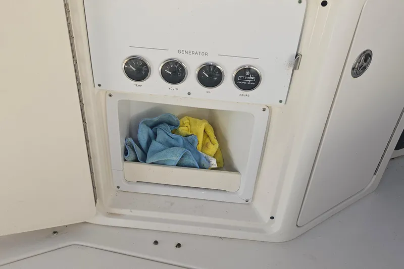 Slide: The Image of Control panel of 2004 Sea Ray 380 Sundancer with cleaning cloths stored below. - 24