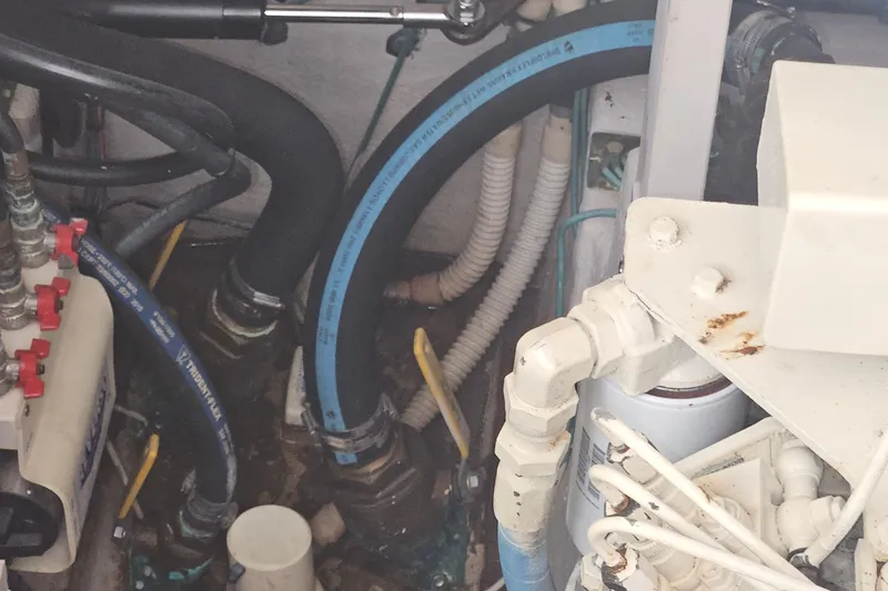 Slide: The Image of Engine compartment of a 2004 Sea Ray 380 Sundancer with hoses and mechanical components. - 28