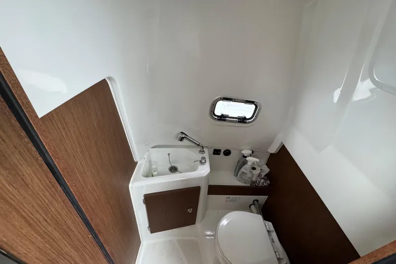 Slide: The Image of 2023 Jeanneau Leader 9.0 CC boat bathroom with sink, toilet, and window. - 10