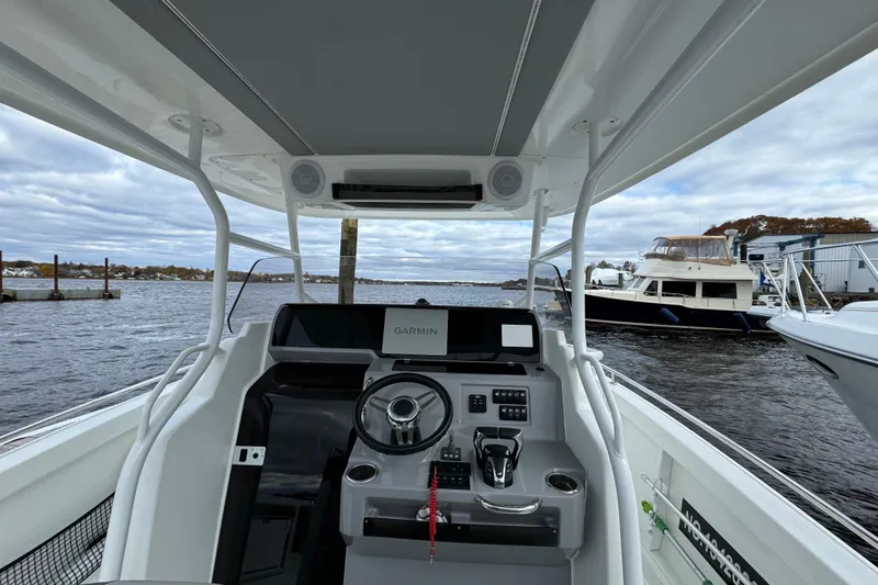 Slide: The Image of 2023 Jeanneau Leader 9.0 CC boat cockpit with Garmin navigation, docked by the water. - 4
