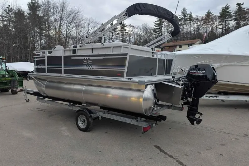 Slide: The Image of 2025 South Bay 16FC SE S Entertainment pontoon boat on trailer, parked outdoors. - 2