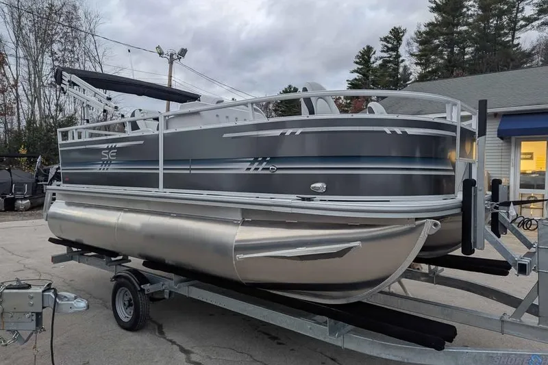Slide: The Image of 2025 South Bay 16FC SE S Entertainment pontoon boat on trailer, parked outdoors. - 5