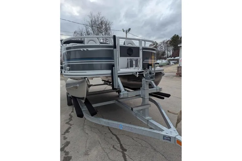 Slide: The Image of 2025 South Bay 16FC SE S Entertainment pontoon boat on trailer, parked outdoors. - 6