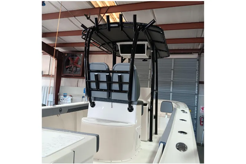 Slide: The Image of 2026 May-Craft 245 Offshore CC boat interior with T-top and seating in a garage. - 13