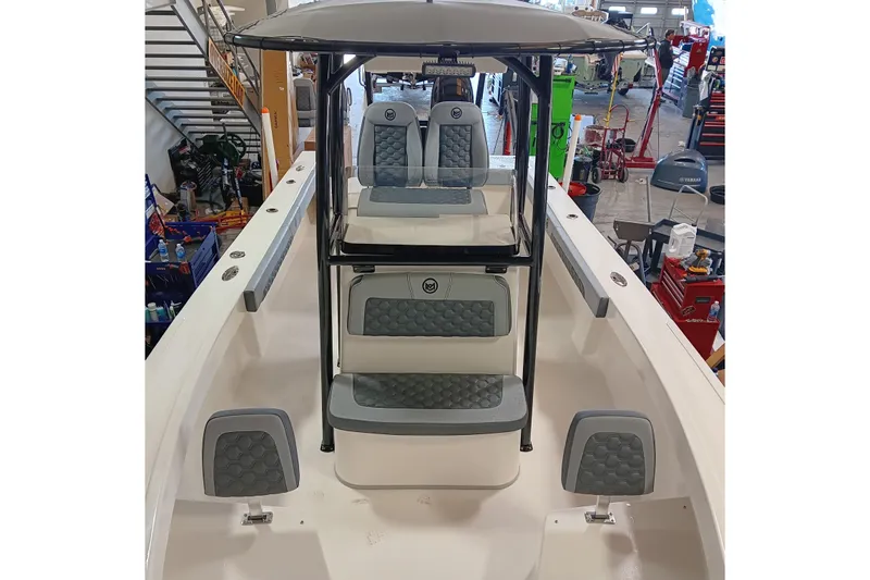 Slide: The Image of 2026 May-Craft 245 Offshore CC boat interior with cushioned seating in a workshop. - 7