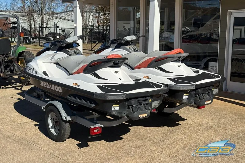 Slide: The Image of Two 2011 Sea-Doo GTI 130 jet skis on a trailer outside a dealership. - 11