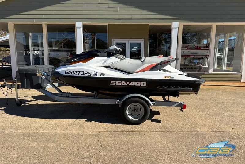 Slide: The Image of 2011 Sea-Doo GTI 130 jet ski on trailer, parked outside a building. - 12