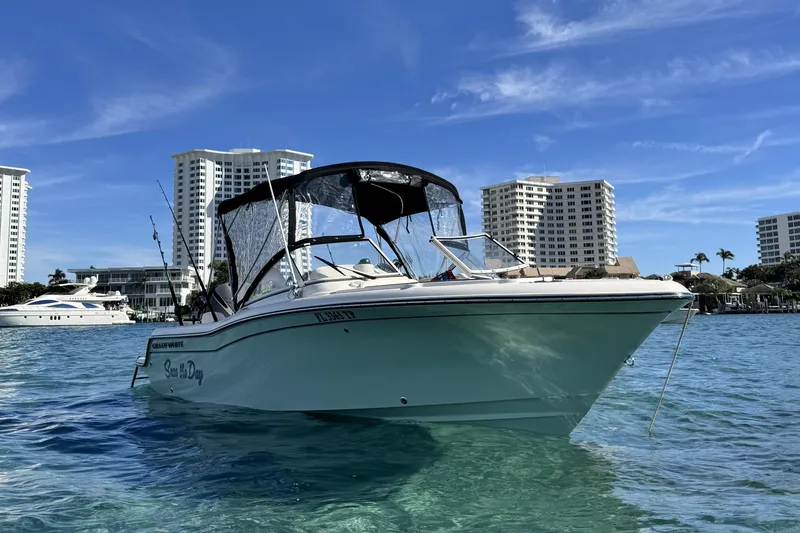 Slide: The Image of 2023 Grady-White Freedom 215 boat on clear water with city skyline backdrop. - 4