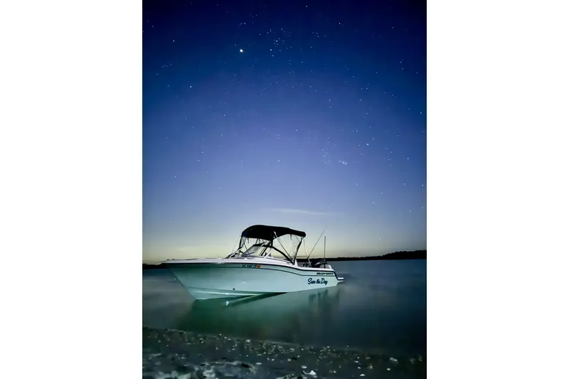 Slide: The Image of 2023 Grady-White Freedom 215 boat under a starry night sky on calm waters. - 5